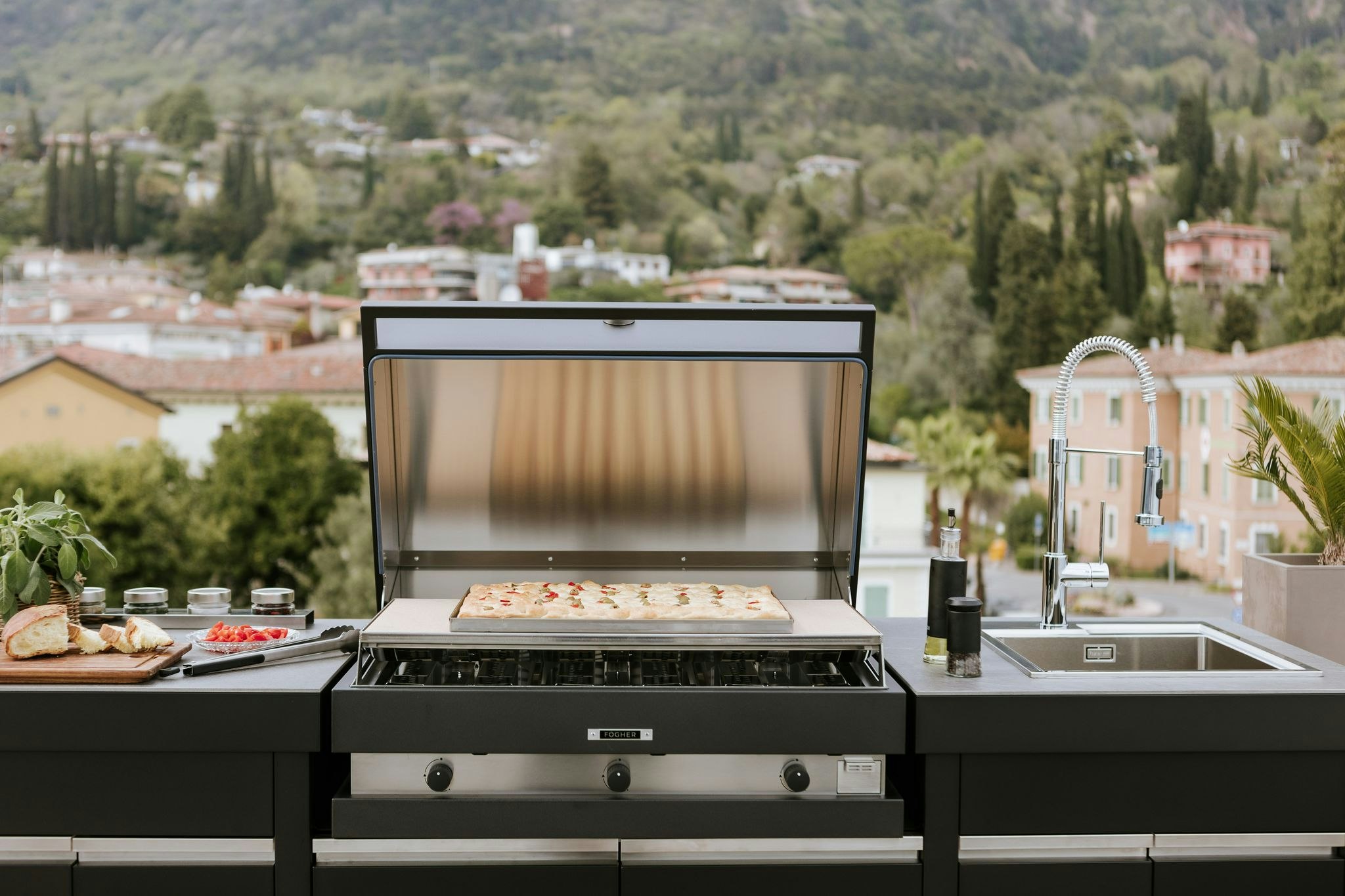 An outdoor kitchen featuring a pizza stone grill, where a delicious pizza cooks to perfection. The grill is adorned with the pizza stone, topped with a sizzling pizza adorned with savory toppings. The scene is set against a backdrop of nature, with the warm glow of the grill and the anticipation of a delectable meal creating an inviting atmosphere.